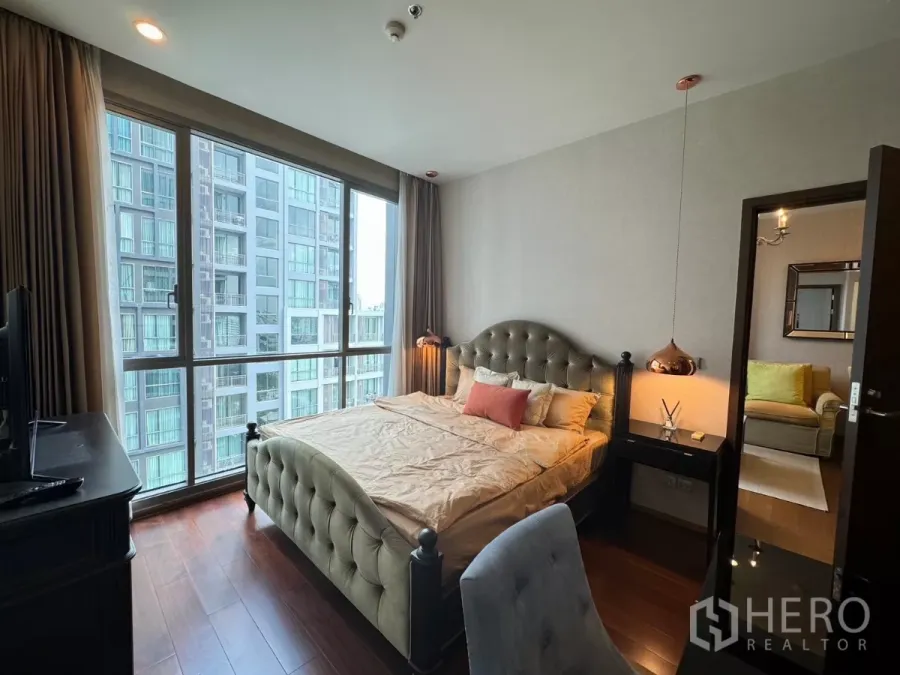 คอนโด ให้เช่าในWatthana, Bangkok - ห้องนอนสว่าง เตียงบุนวม โคมไฟแขวน และหน้าต่างบานใหญ่รับวิวอาคารรอบข้าง