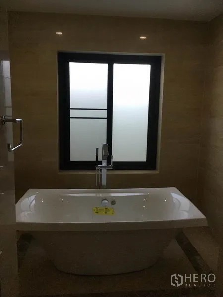 独立式住宅 出售在Khlong Toei, Bangkok - 独立浴缸特写，位于磨砂窗下，配现代龙头。