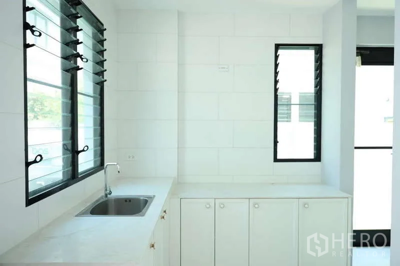 独立式住宅 出租或出售在Saphan Sung, Bangkok - 独立中式厨房，水槽、白色橱柜和百叶窗