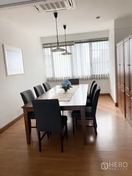 Condominium for rent in Yan Nawa, Bangkok - Bright dining room with long wooden table and pendant lights.