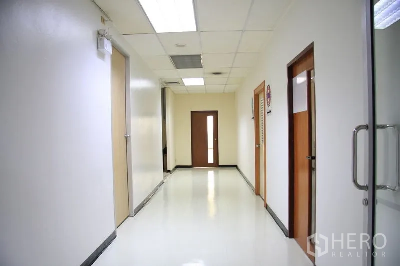 สำนักงาน ให้เช่าในChatuchak, Bangkok - โถงทางเดินสว่าง ผนังสีขาว เพดานฝ้าพร้อมไฟ และประตูสำนักงานหลายห้อง