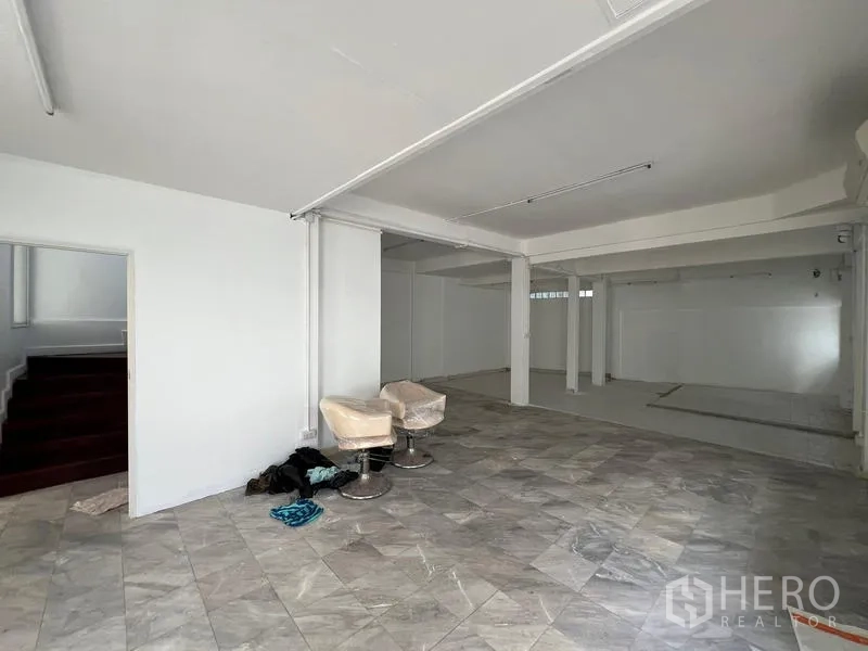 Home Office for rent in Watthana, Bangkok - Open tiled ground-floor area near the staircase, suitable for reception or showroom.