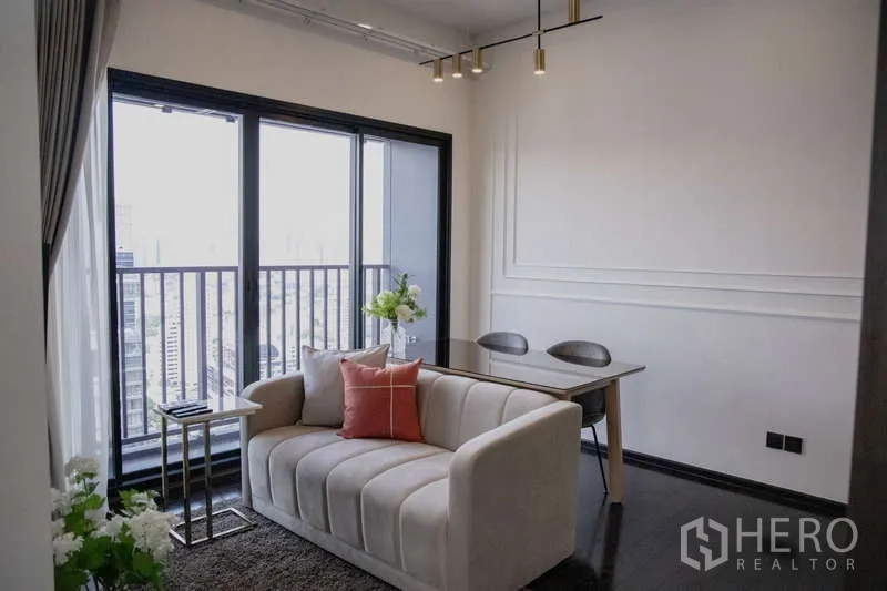 คอนโด ให้เช่าในWatthana, Bangkok - โซนรับแขกแบบโอเพ่นแปลน โซฟานุ่ม ชุดทานอาหาร และประตูกระจกเต็มบานออกสู่ระเบียง