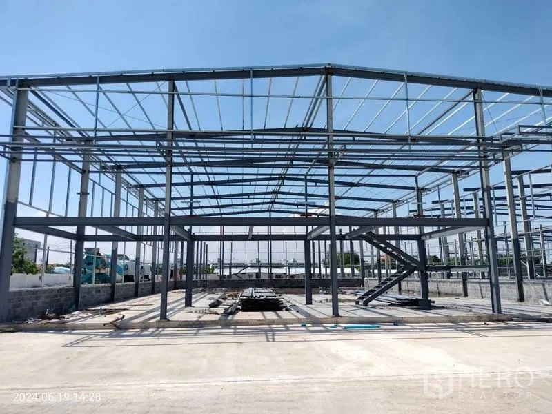 货栈 出租在Samut Prakan - 双跨钢架仓库正立面，设中央楼梯与开放式楼面。