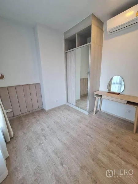 คอนโด ให้เช่า - ห้องนอนรองพร้อมตู้เสื้อผ้าบานกระจก โต๊ะเครื่องแป้ง และเครื่องปรับอากาศ