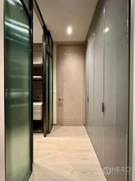 Condominium for rent or sale - Hallway with frosted glass partition and full-height wardrobes leading to a bedroom.