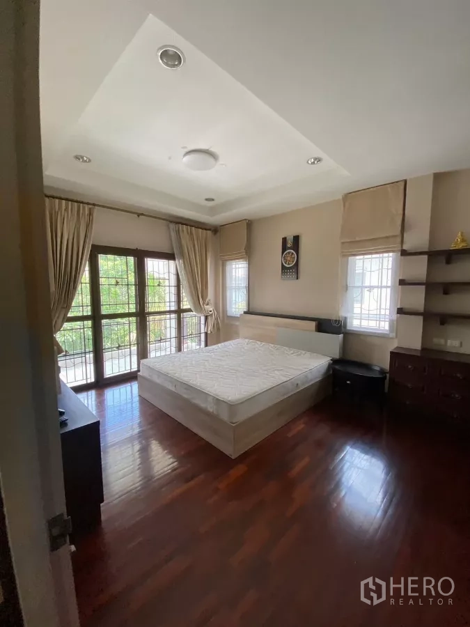 独立式住宅 出租或出售在Mueang Nonthaburi, Nonthaburi - 主卧木地板，带阳台门与大窗，采光充足。