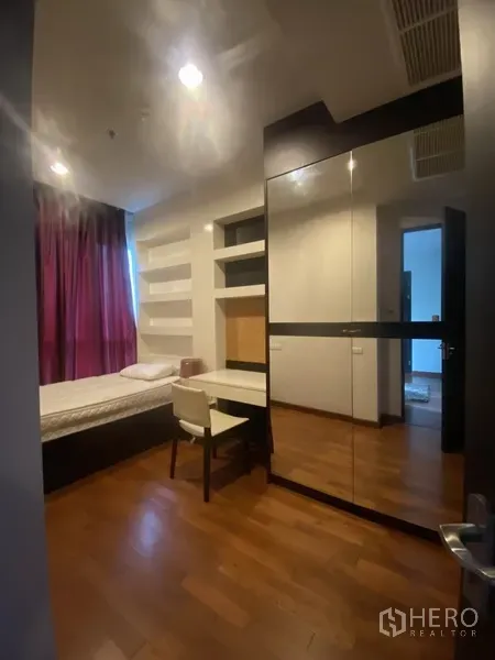 คอนโด ให้เช่าในPathum Wan, Bangkok - ห้องนอนรองมีเตียงเดี่ยว ตู้เสื้อผ้าบานกระจก โต๊ะทำงานพร้อมชั้นวาง และผ้าม่านสีม่วง