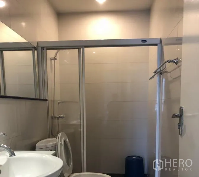 คอนโด ให้เช่าในPathum Wan, Bangkok - ห้องน้ำมีตู้ฝักบัวกระจกบานเลื่อน อ่างล้างหน้า และเครื่องซักผ้าในห้อง