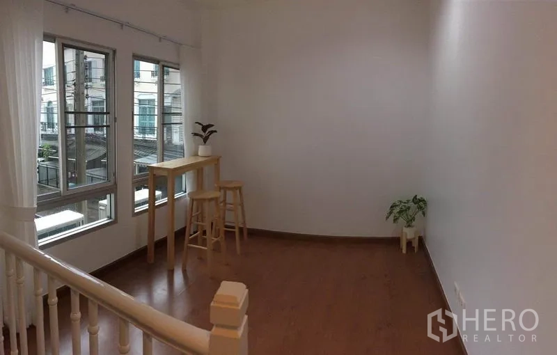 ทาวน์เฮาส์ ให้เช่าในLat Phrao, Bangkok - โถงชั้นบนสว่างด้วยหน้าต่างมุม มีโต๊ะบาร์และต้นไม้กระถาง