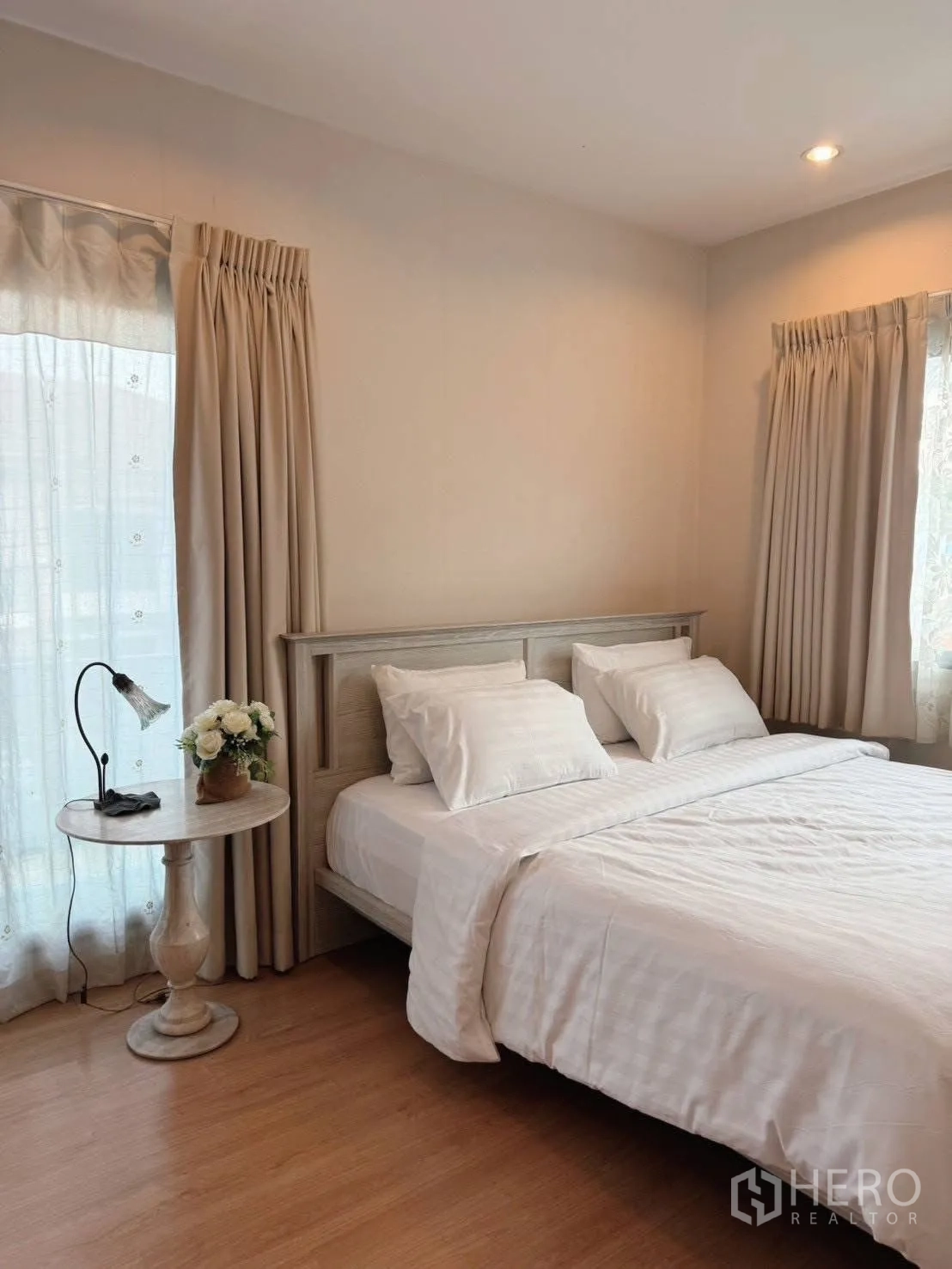 Detached House for rent or sale in Suan Luang, Bangkok - Cozy bedroom with bedside table, lamp and neutral curtains.