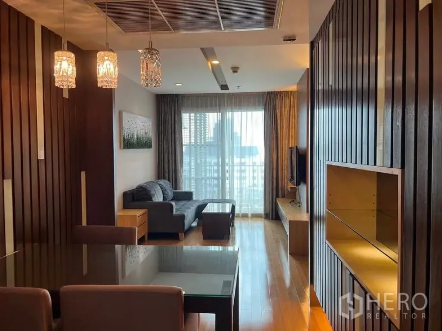 คอนโด ให้เช่าในKhlong Toei, Bangkok - ห้องนั่งเล่นและทานข้าว โคมไฟคริสตัล โซฟา ชั้นวางทีวี และประตูกระจกสู่ระเบียง