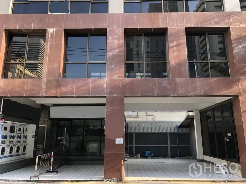 零售空间 出租在Watthana, Bangkok - 素坤逸临街底层商铺门面，落地玻璃、铺装前庭与遮蔽出入口，靠近BTS阿索克站。