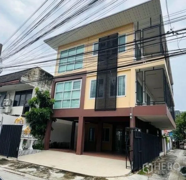 Home Office for rent in Bang Sue, Bangkok - Front facade of a modern home office showing covered carport and vertical metal sun screens.