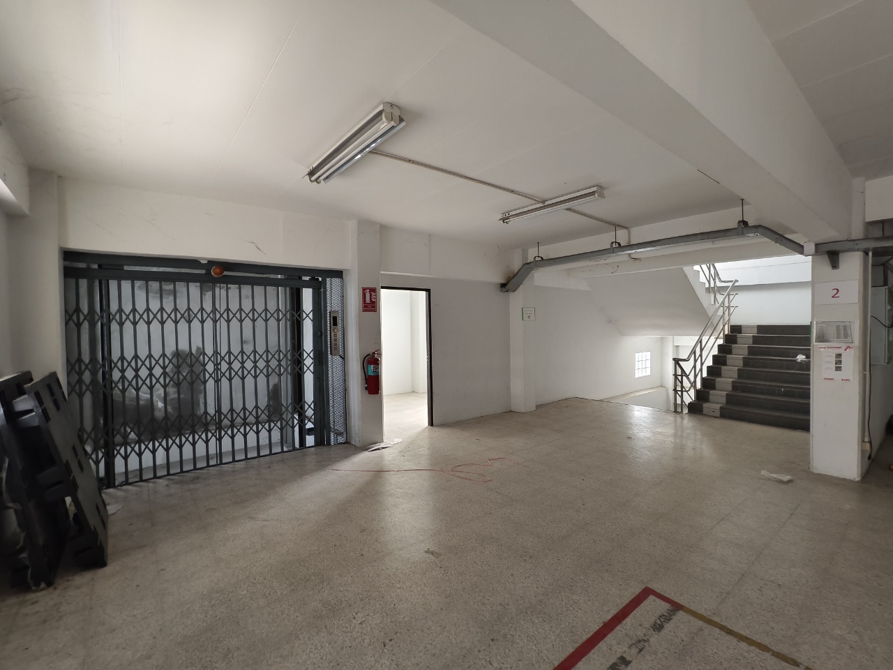 Warehouse for rent in Lat Krabang, Bangkok - Cargo lift entrance and twin staircases within a bright loading and staging area.