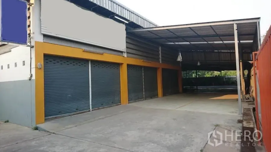 货栈 出租在Lak Si, Bangkok - 临街仓库外观，多个卷闸门，带大面积有顶装卸区。