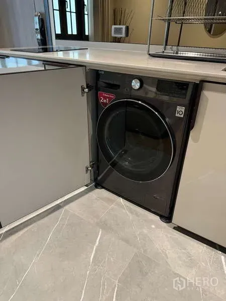 Condominium for rent in Watthana, Bangkok - Built-in 2-in-1 washer dryer concealed inside the kitchen cabinet.