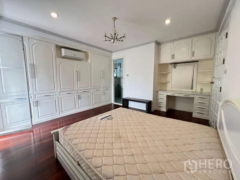 Detached House for rent in Chatuchak, Bangkok - Bedroom with built-in wardrobes, dressing table and ensuite access.