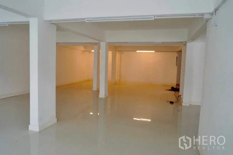 Office Space for sale in Khan Na Yao, Bangkok - Ground-floor open area with columns and shiny tile flooring, ideal for reception or showroom.