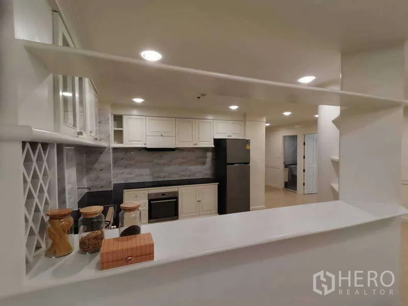 อพาร์ทเมนท์ ให้เช่า - ช่องเสิร์ฟพร้อมชั้นวาง มองเข้าสู่ครัวบิวท์อินตู้ลอย