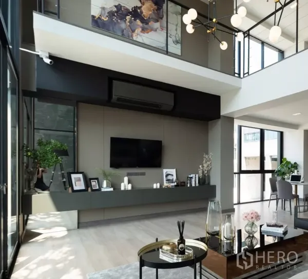 Home Office for sale in Bang Kapi, Bangkok - Double-height living and workspace with floor-to-ceiling glass, TV wall, and modern chandelier.