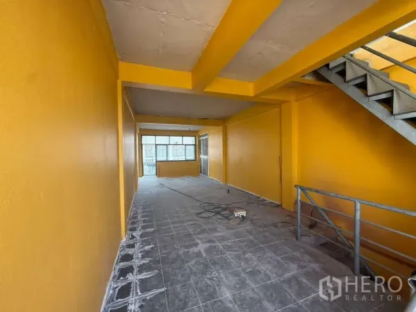 Home Office for rent in Khlong Toei, Bangkok - Open-plan yellow-painted floor with grey tile and internal staircase, ideal for office layout.