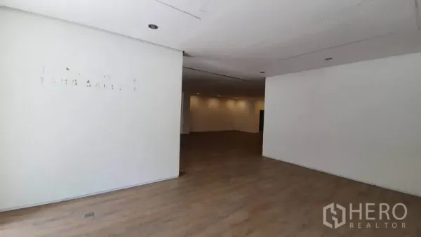 零售空间 出租在Khlong Toei, Bangkok - 开放式零售空间，白色隔墙、嵌灯与木纹地板。