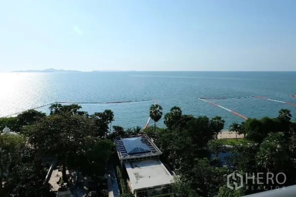 Condominium for rent or sale in Bang Lamung, Chon Buri - Panoramic Gulf of Thailand sea view with sandy beach and palm trees from a high floor.