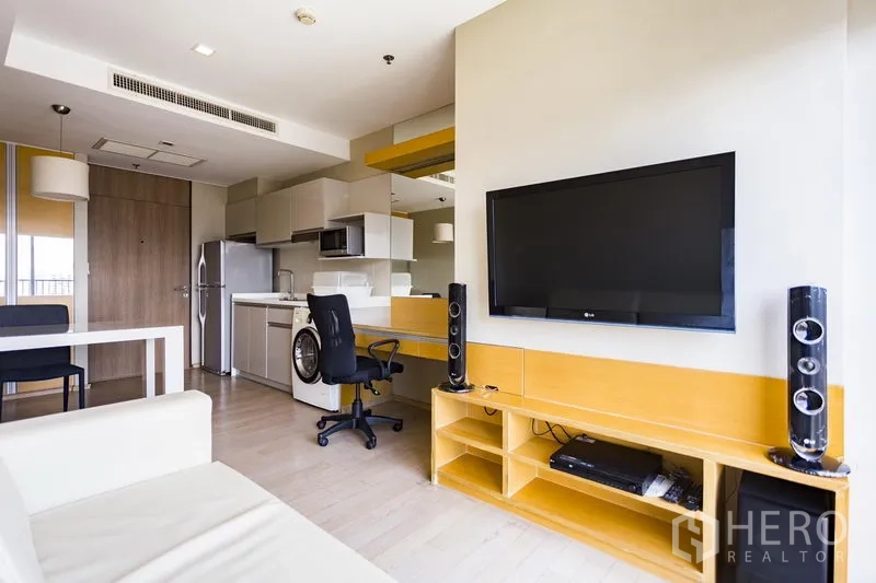 คอนโด ให้เช่าในKhlong Toei, Bangkok - พื้นที่นั่งเล่นแบบเปิดโล่งที่ Noble Remix ทองหล่อ มีทีวีติดผนัง โต๊ะทำงาน และมุมครัว