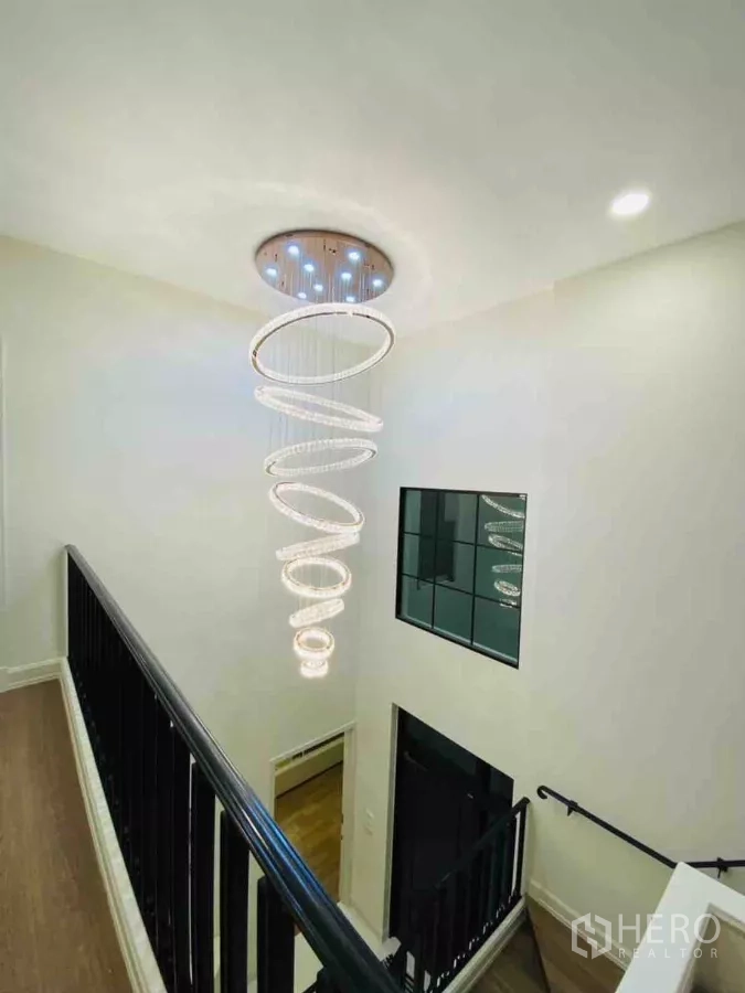 Detached House for rent or sale in Saphan Sung, Bangkok - Stairwell with dramatic spiral chandelier and black handrail