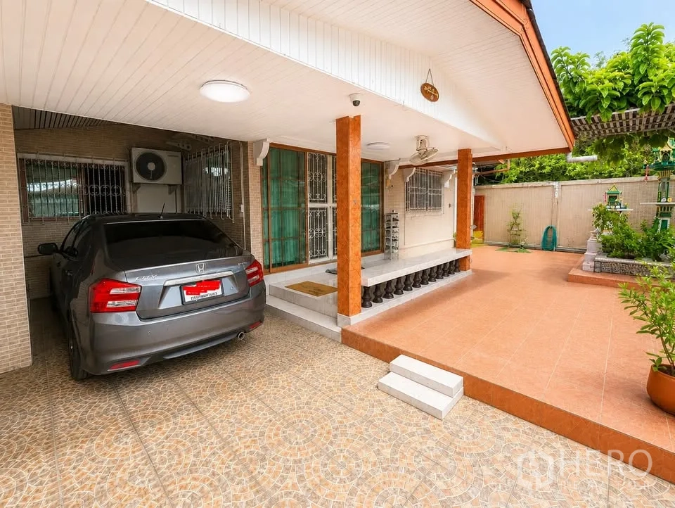 Detached House for rent in Prawet, Bangkok - Covered carport and front terrace with pillars and planting beds.