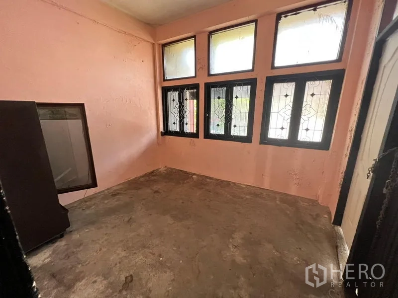 店屋 出租在Phaya Thai, Bangkok - 二层房间，粉色墙面，多扇带格窗，裸露水泥地