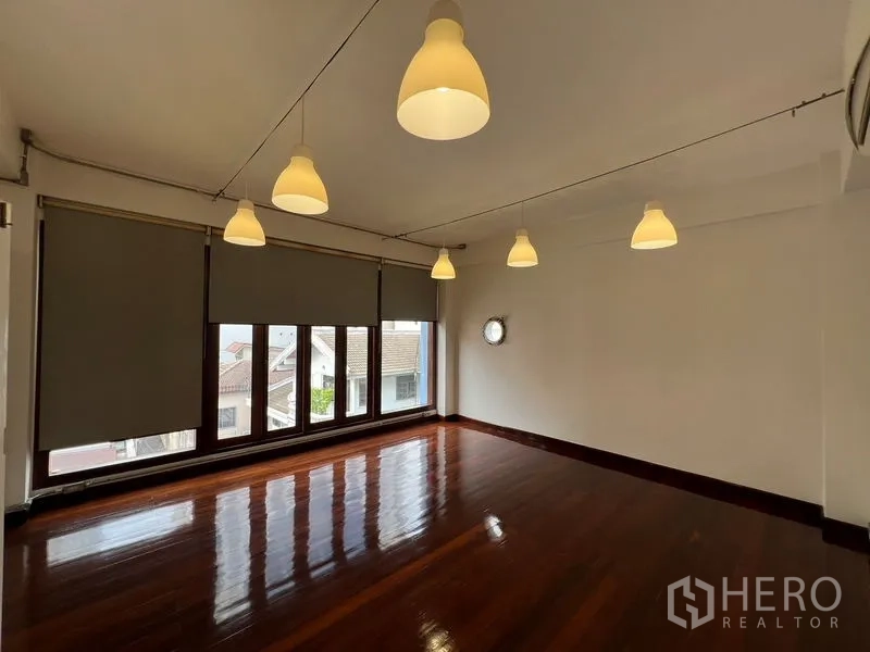 Office Space for rent in Watthana, Bangkok - Spacious office area with roller shades, multiple pendant lights, and shiny hardwood flooring.