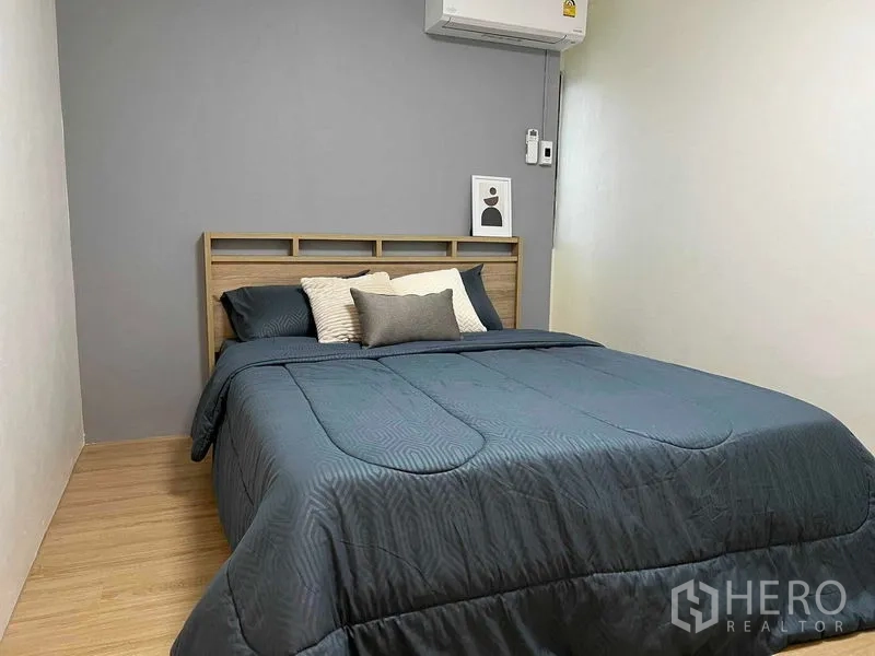 Condominium for rent in Ratchathewi, Bangkok - Second bedroom with gray accent wall, air conditioner, and a double bed.