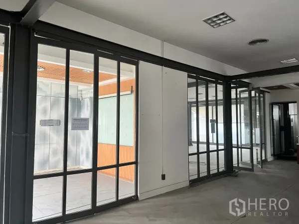 零售空间 出租在Watthana, Bangkok - 钢框玻璃隔断与平开门分隔的展厅角落