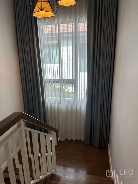 บ้าน ให้เช่าในLam Luk Ka, Pathum Thani - โถงบันไดมีหน้าต่าง ผ้าม่านสองชั้น และโคมไฟแขวน