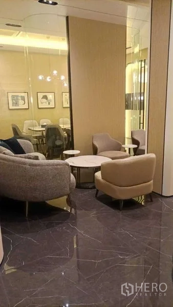 零售空间 出租 - 舒适等候角，软包单椅与圆几，临玻璃墙。