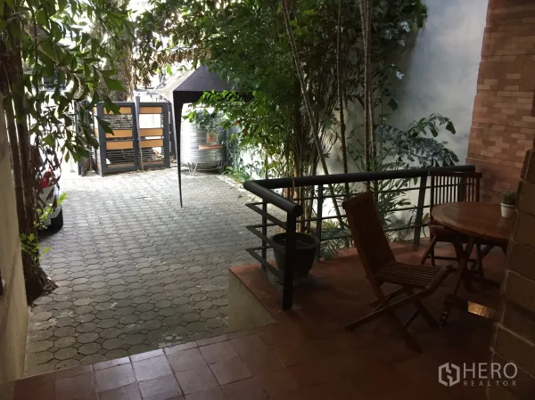 ทาวน์เฮาส์ ให้เช่าในWatthana, Bangkok - เฉลียงหน้าบ้านพร้อมชุดโต๊ะไม้ และทางเข้า–ที่จอดรถปูบล็อก