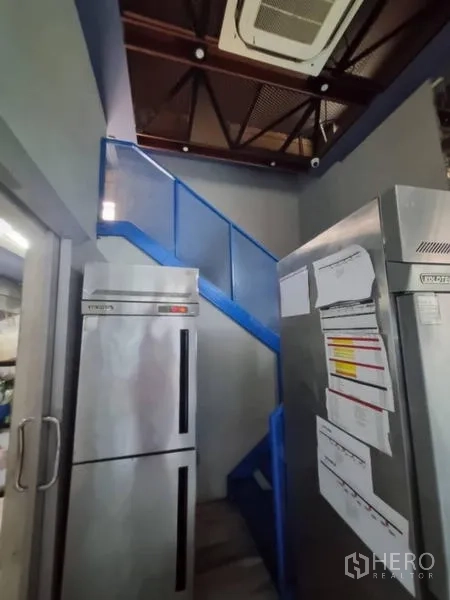 零售空间 出租在Bang Rak, Bangkok - 储藏区，双开门冰箱与通往夹层的蓝色楼梯