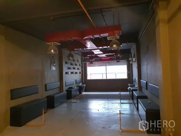 อาคารพาณิชย์ ให้เช่าในKhlong Toei, Bangkok - พื้นที่ชั้นบนกว้างยาว มีเบาะนั่งติดผนัง โคมไฟสไตล์อุตสาหกรรม และท่อลมสีแดง