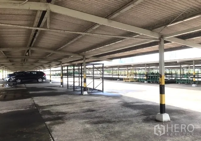 工厂 出租在Bang Bua Thong, Nonthaburi - 大型金属车棚下的停车与储物架。