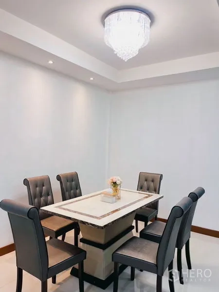 联排别墅 出租在Huai Khwang, Bangkok - 六人餐桌套装置于现代吊灯下，房间洁白明亮。