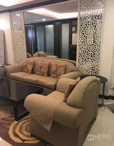 ทาวน์เฮาส์ ให้เช่าในKhlong Toei, Bangkok - ห้องรับแขกอีกมุม โซฟาสีเบจ แผงตกแต่งลายฉลุพร้อมกระจก และไฟฝ้าซ่อนไฟ