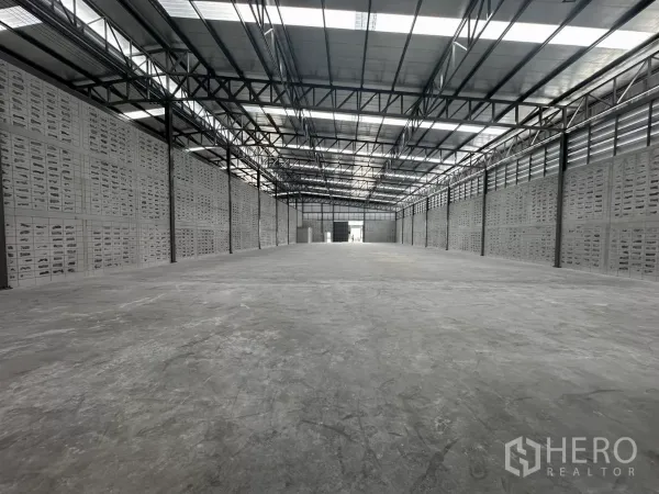 Warehouse for rent in Khlong Toei, Bangkok - Long‑span storage hall with ventilation block walls and translucent roof panels.