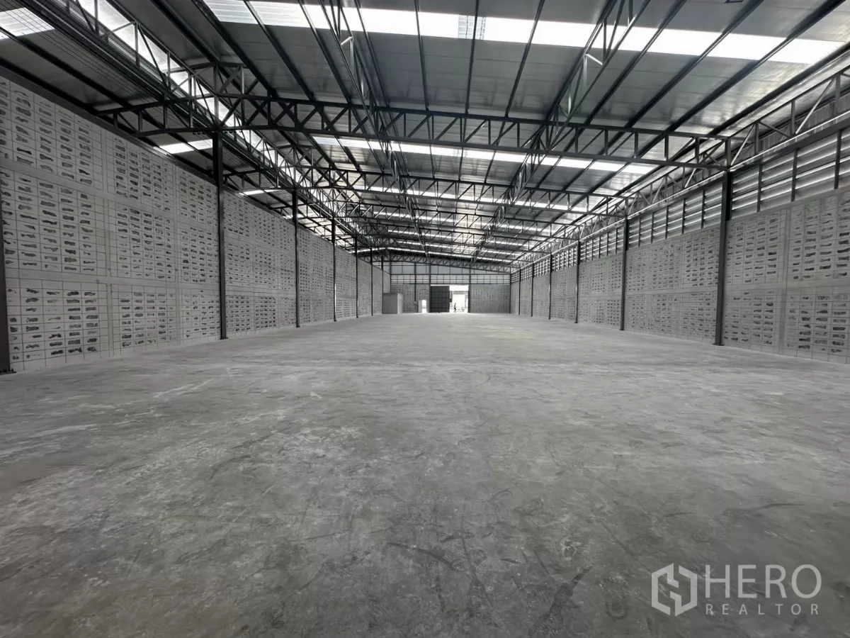 Warehouse for rent in Khlong Toei, Bangkok - Long‑span storage hall with ventilation block walls and translucent roof panels.