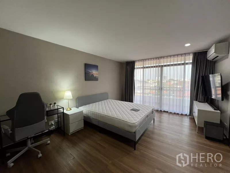 ทาวน์เฮาส์ ให้เช่าหรือขายในSuan Luang, Bangkok - ห้องนอนรับแสงดี เตียง โต๊ะทำงาน ทีวี และผ้าม่านโปร่ง