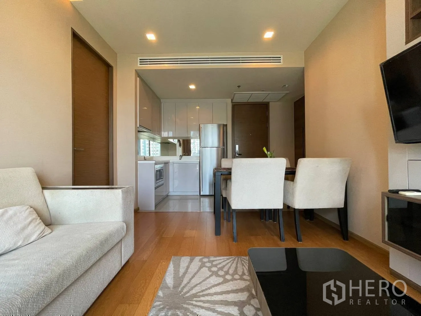 Condominium for rent or sale in Bang Rak, Bangkok - View from living room toward kitchen and dining with wood flooring.