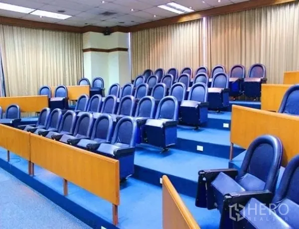 Office Space for rent in Lak Si, Bangkok - Tiered training room with blue upholstered seats and full-length curtains.