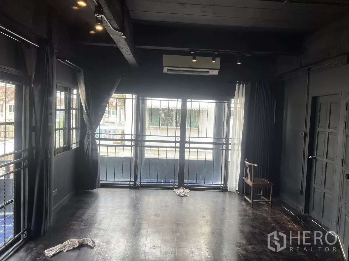 Home Office for rent in Wang Thonglang, Bangkok - Upper-floor room with balcony access, large windows, and dark wood flooring.