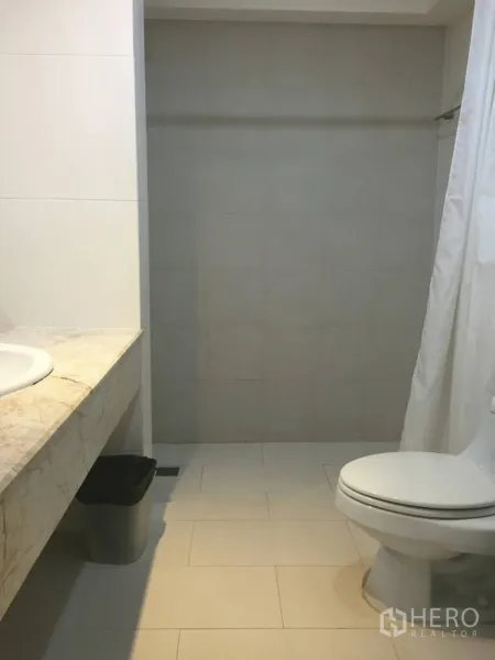 คอนโด ให้เช่าในWatthana, Bangkok - ห้องน้ำสมัยใหม่พร้อมเคาน์เตอร์หินอ่อน อ่างล้างหน้า โถสุขภัณฑ์ และพื้นที่อาบน้ำพร้อมผ้าม่าน